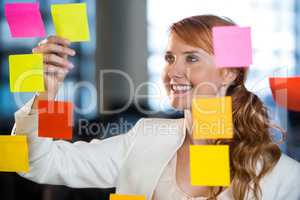 Businesswoman seen through glass with adhesive notes
