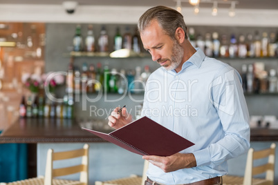 Confident man writing in a file