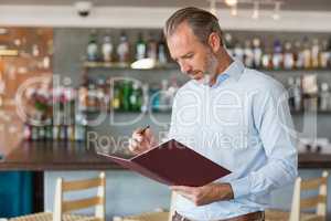 Confident man writing in a file
