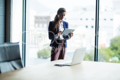 Focused woman using digital tablet in office