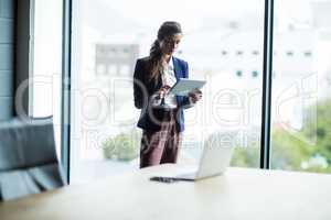 Focused woman using digital tablet in office