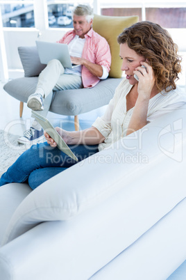 Woman talking on phone while holding tablet by man