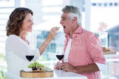 Woman feeding food to man