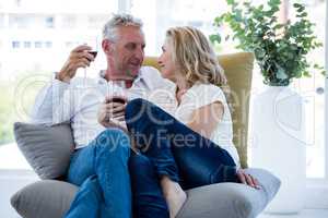 Romantic mature couple having red wine at home