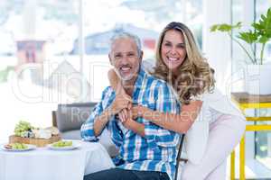 Cheerful woman embracing husband in restaurant