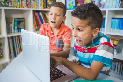 Schoolkids using laptop in library