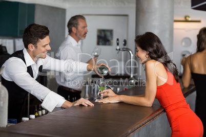 Waiter pouring cocktail into cocktail glass