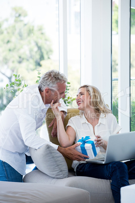 Romantic couple with gift and laptop