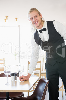 Waiter standing at table with empty glass