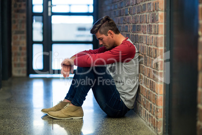 Stressed man sitting in corridor