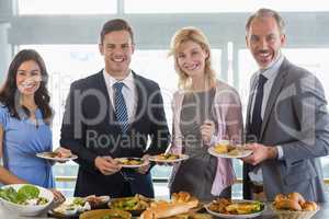 Portrait of business colleagues serving themselves at buffet lun