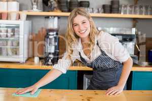 Waitress cleaning cafe counter