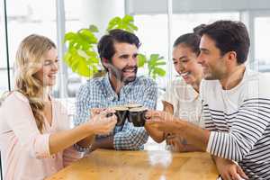 Group of happy friends toasting cup of coffee