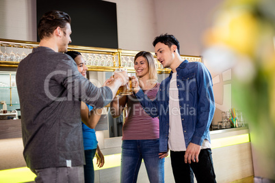 Male and female friends toasting wine at bar