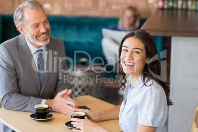 Business colleagues interacting with each other while having tea