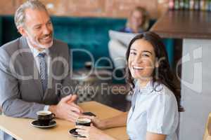 Business colleagues interacting with each other while having tea