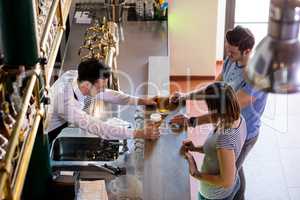 Bartender serving beer to couple