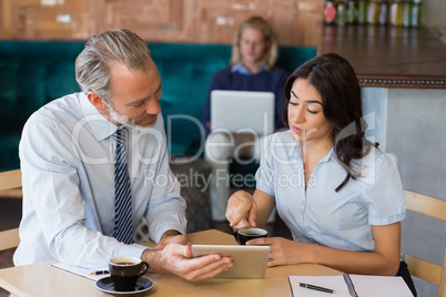Man and woman using a digital tablet during meeting Man and woman using a digital tablet during meeting