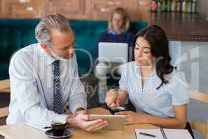 Man and woman using a digital tablet during meeting