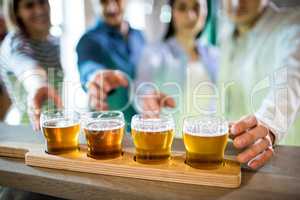 Friends reaching towards beer sampler