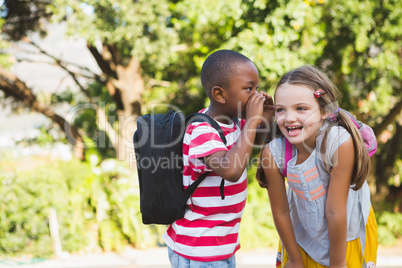 Boy whispering a secret in girls ear