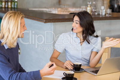 Business colleagues interacting with each other while having tea