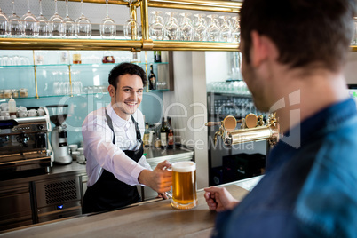 Bartender serving beer to male customer