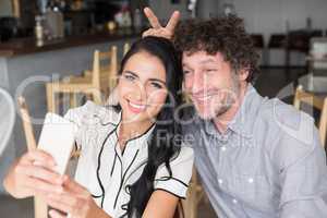 Couple taking a selfie in cafeteria