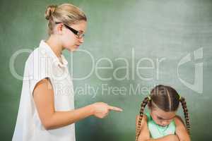 Female teacher shouting at girl in classroom