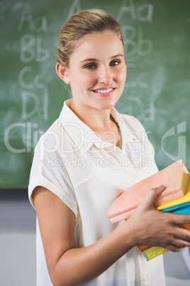 Portrait of smiling school teacher in classroom