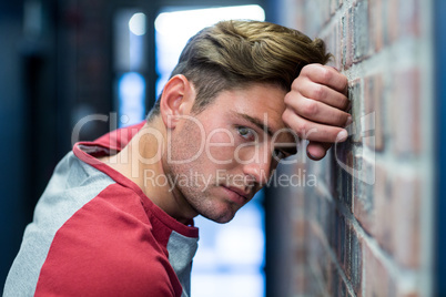 Portrait of stressed man leaning on wall