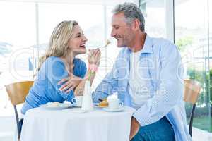 Happy mature woman feeding man