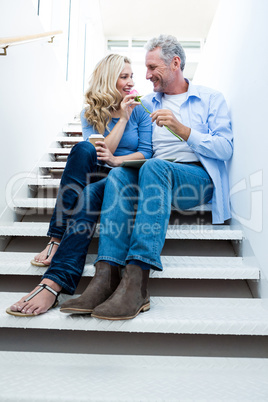 Smiling man giving flower to woman