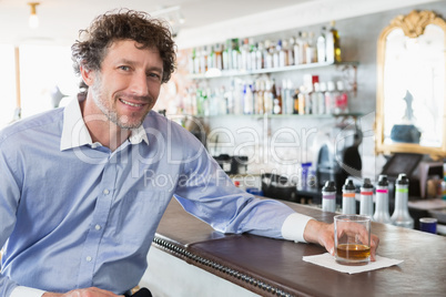 Happy man holding a glass of alcohol