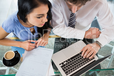 Businessman discussing with colleague over laptop