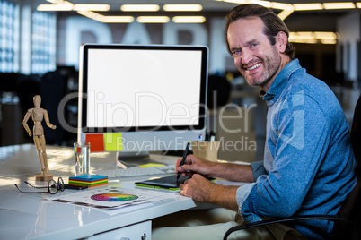 Photo editor smiling while working on graphics tablet