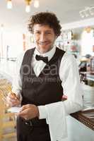 Portrait of waiter holding notepad and pen