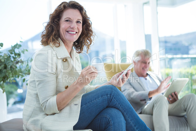 Portrait of smiling woman by man holding mobile phone