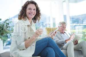 Portrait of smiling woman by man holding mobile phone