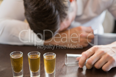 Drunken man sleeping on a bar counter