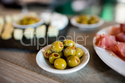 Green olives in bowl on table