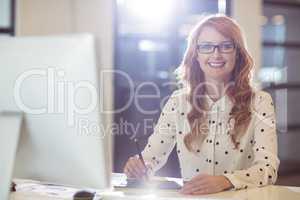 Young businesswoman using graphics tablet at desk