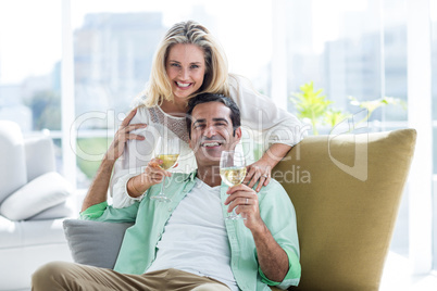 Mid adult couple holding winglasses at home