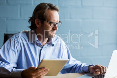 Focused man using laptop in office