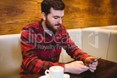 Man using mobile phone at table in restaurant