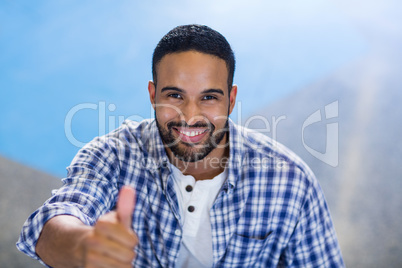 Businessman gesturing thumbs up in office