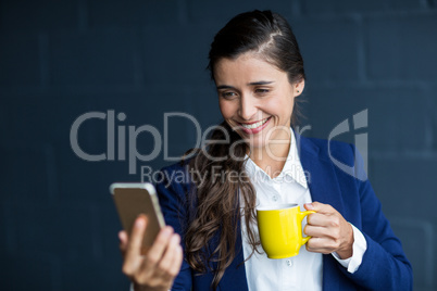 Happy woman taking selfie in office