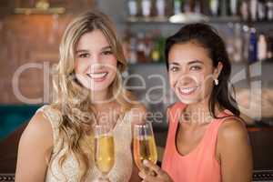 Portrait of two women holding a glass of champagne