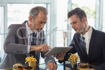 Businessmen using digital tablet in restaurant