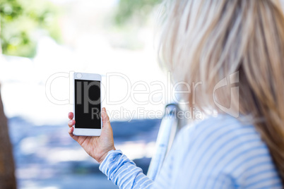 Woman holding smartphone on street